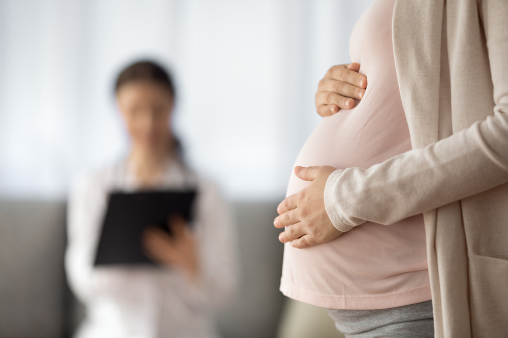 A close-up shot of a pregnant woman’s stomach.