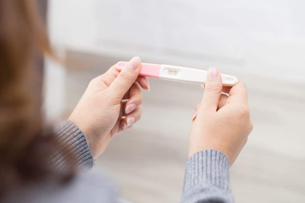 A woman holding a pregnancy test