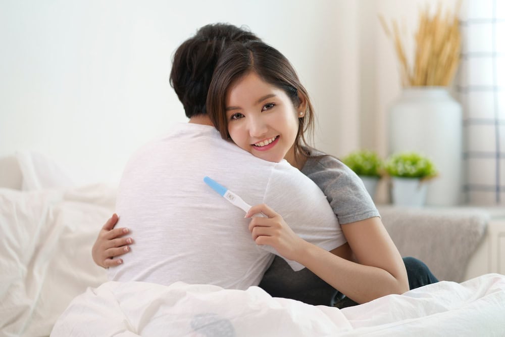 Couple using an hCG pregnancy test after embryo transfer with a positive result