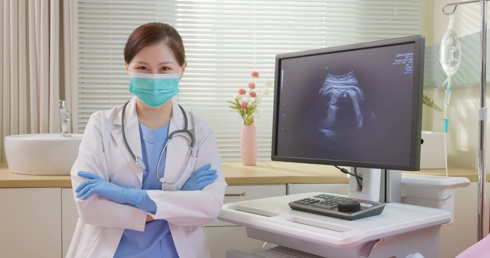 Doctor performing an ultrasound to check for uterine fluid and embryo implantation success.
