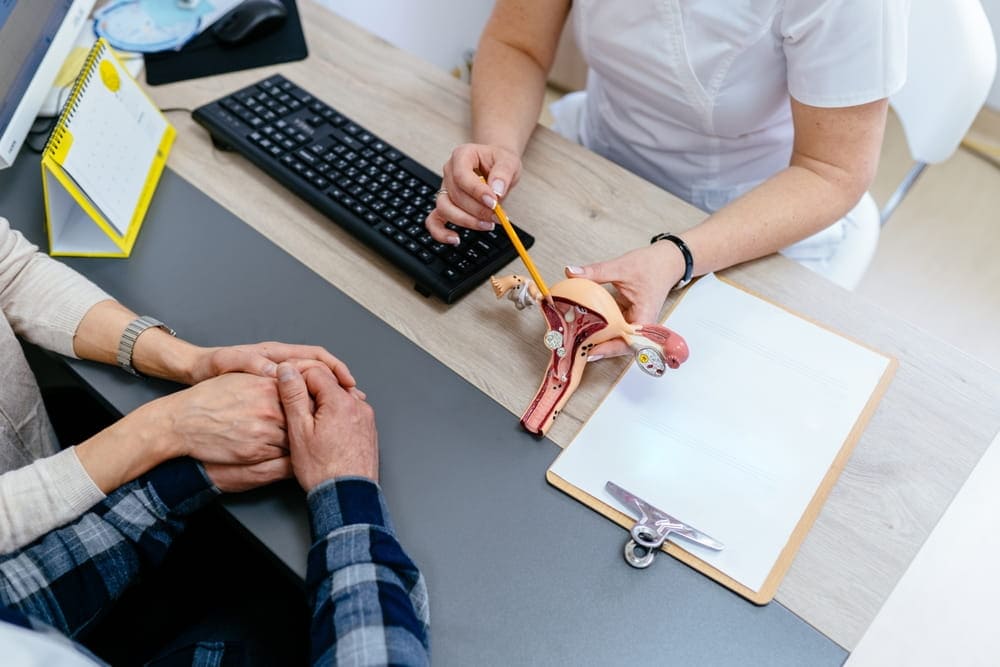 A doctor explaining the steps of IUI treatment after a pelvic infection to a couple.